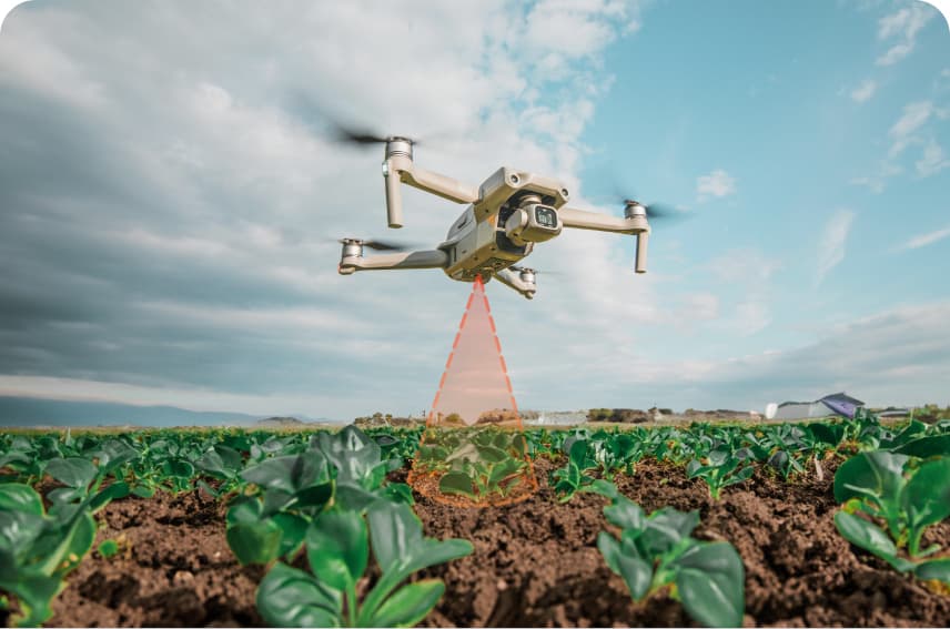 Imagen de un drone sobrevolando un campo agrícola y emitiendo un haz de rayos laser